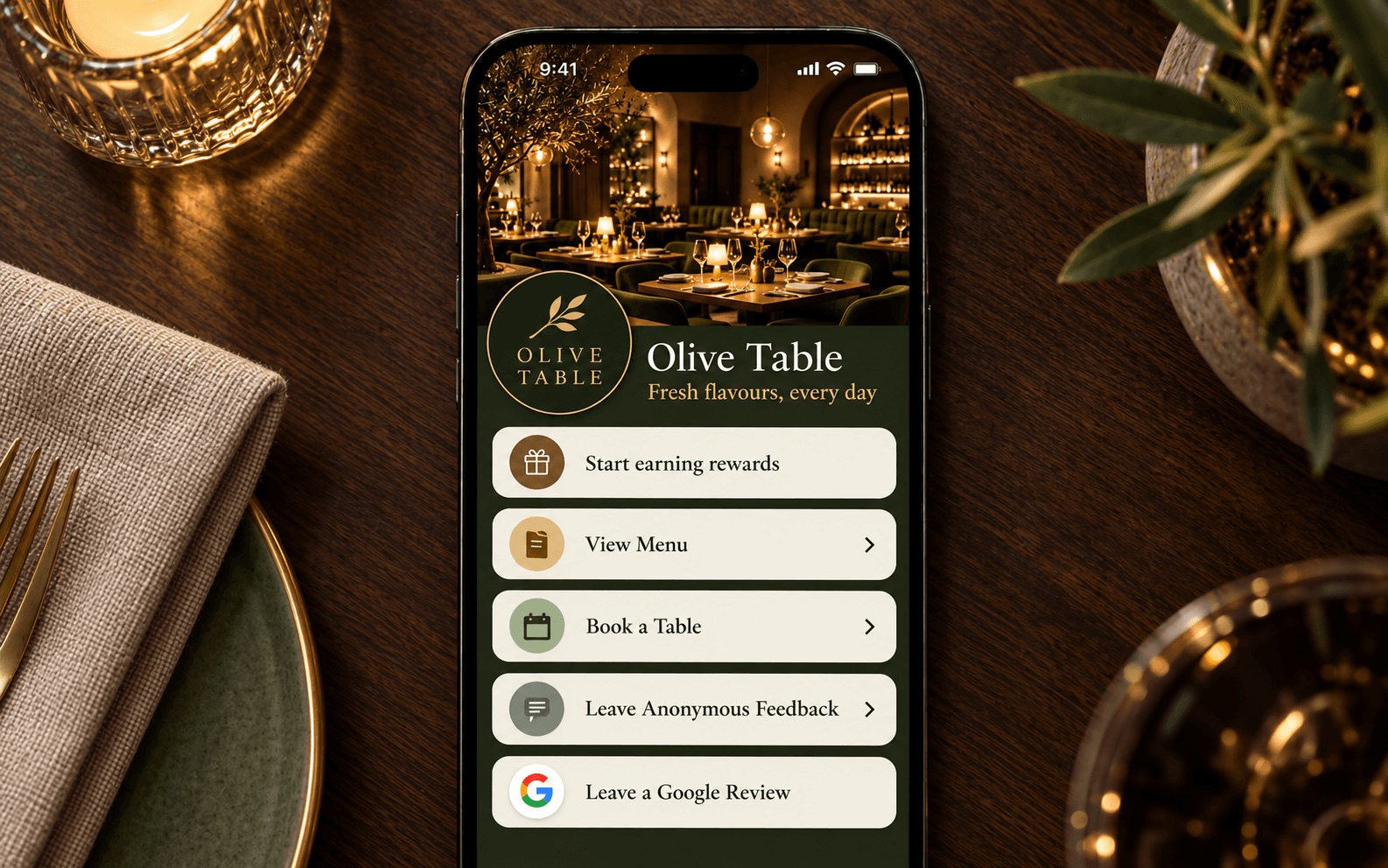 Olive Table restaurant app shown on iPhone with dinner setting flat-lay
